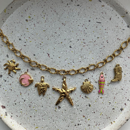 Gouden bedelketting met zeven bedels: zon, roze met goud, schildpad, zeester, schelp, visje met kleur, cowboylaars | Zafia Jewellery