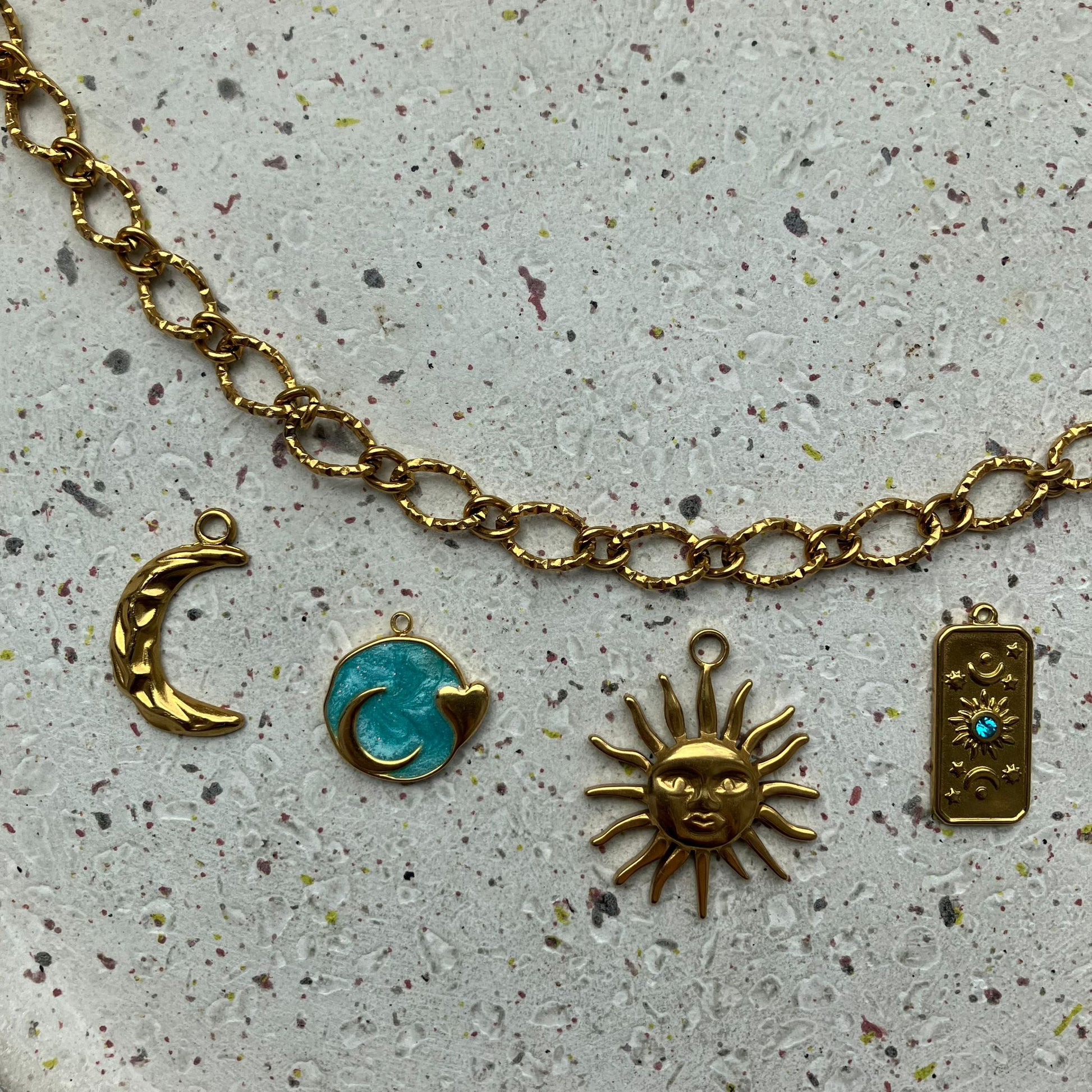 Gouden bedelketting met blauwe accenten en centraal een sierlijke gouden zon | Zafia Jewellery