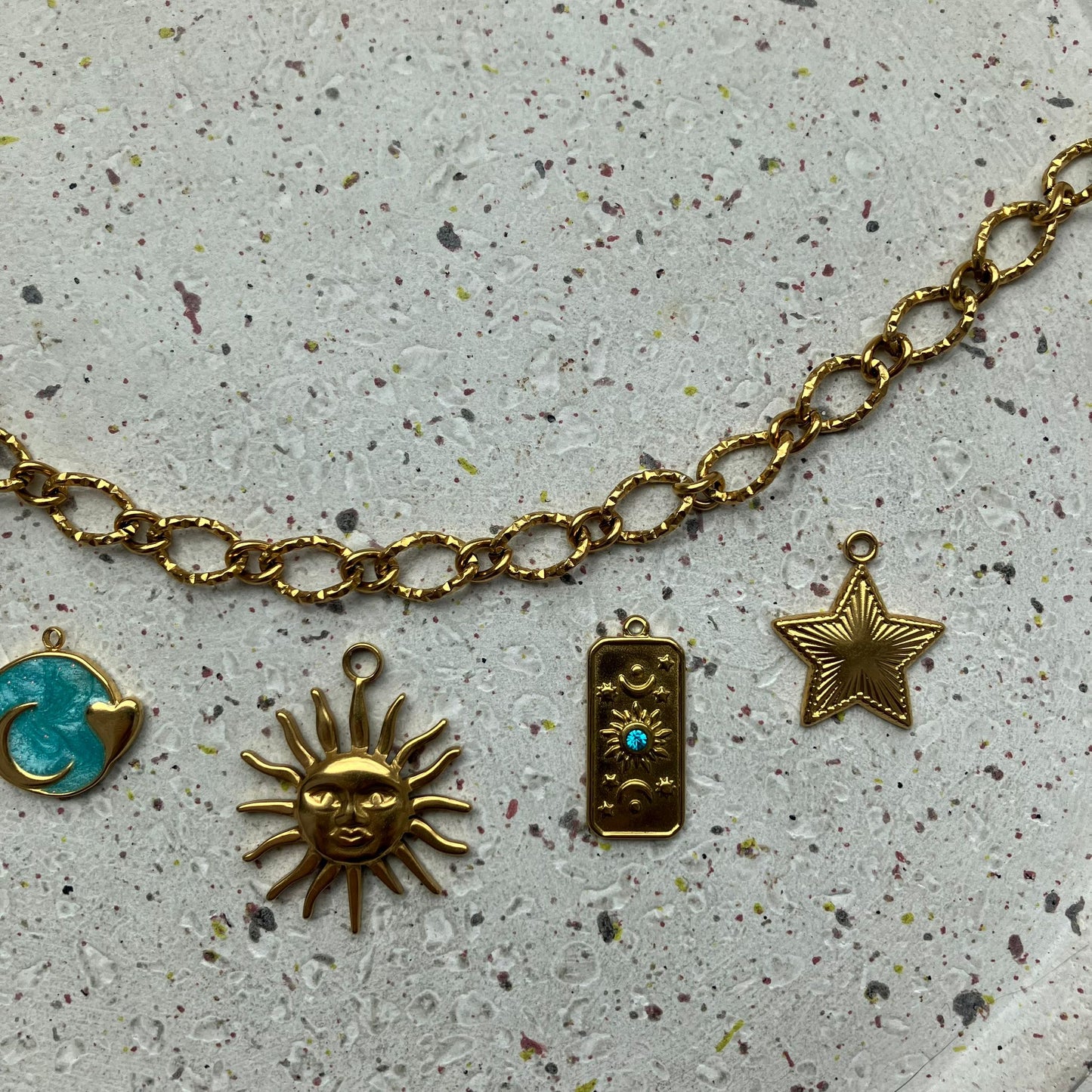 Gouden bedelketting met blauwe accenten en centraal een sierlijke gouden zon | Zafia Jewellery