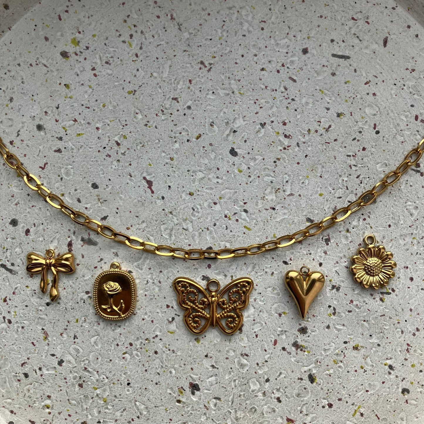 Gouden bedelketting met strikje, gouden plaat met roos, vlinder, hartje en zonnebloem | Zafia Jewellery